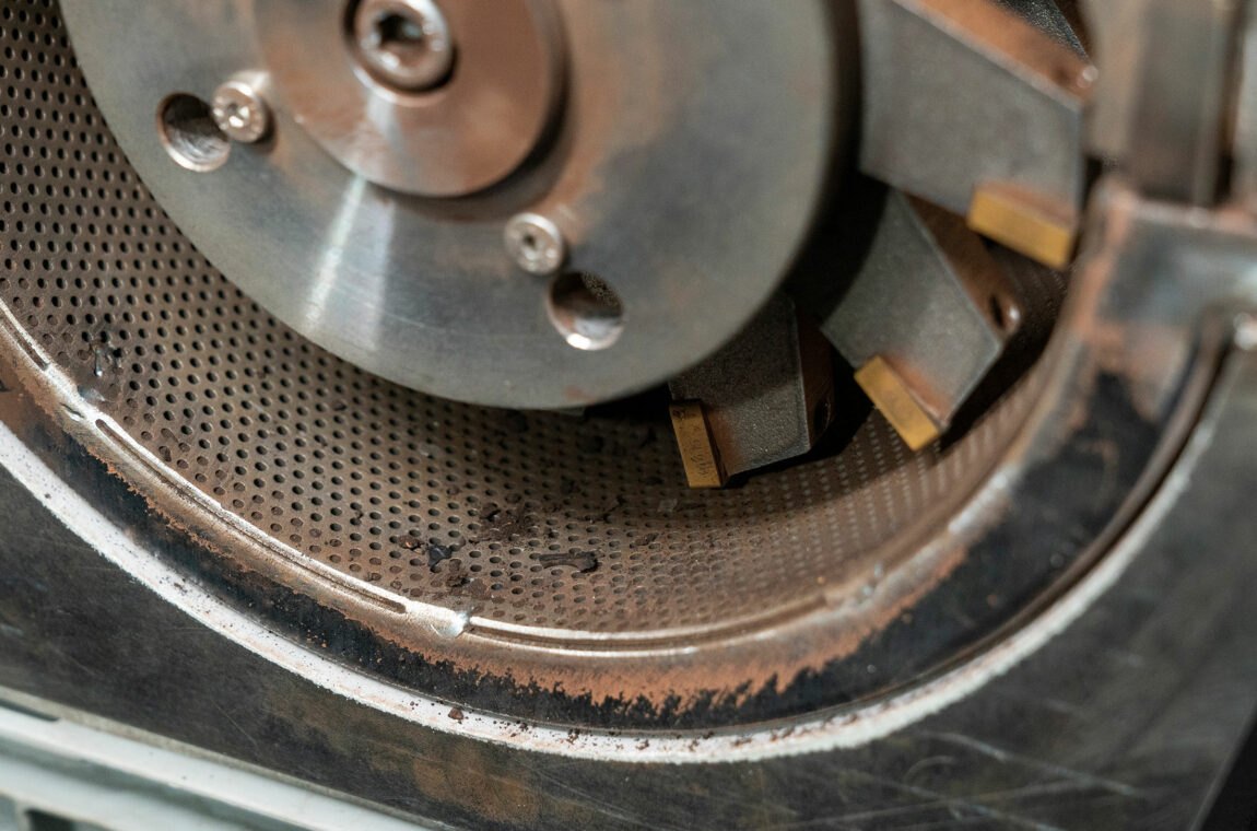 Hammer cutting mill - close-up of the perforated basket and the cutting rotor after crushing charcoal fibers
